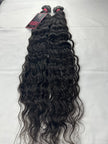 Extensions de cheveux indiens vierges, bouclés, lâchement attachés en point plat.