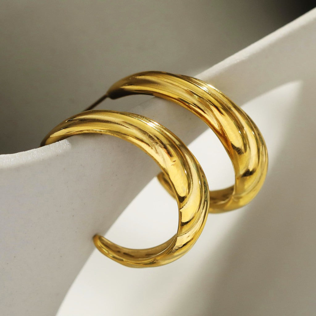 Boucles d'oreilles créoles dorées DORSINA à lignes texturées. Inspirées par la nature.