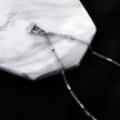 Collier ABENI avec chaîne à perles tubulaires et pendentif cadenas pavé de zircons en argent.
