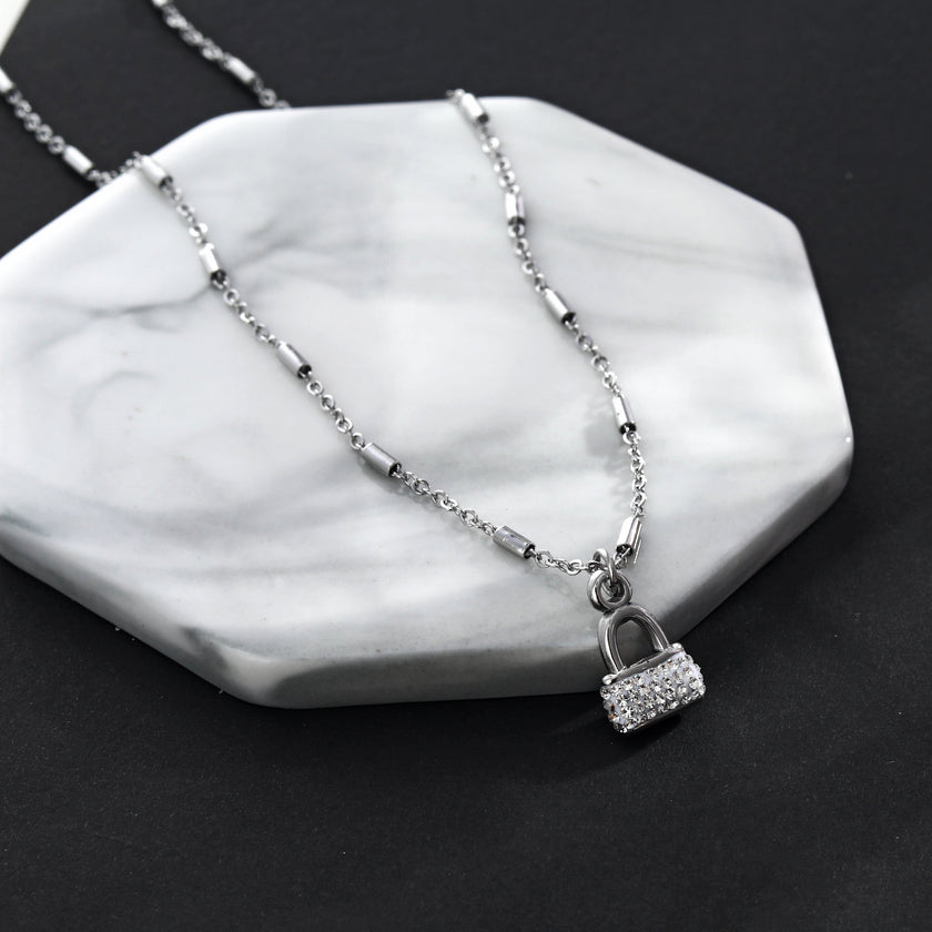 Collier ABENI avec chaîne à perles tubulaires et pendentif cadenas pavé de zircons en argent.
