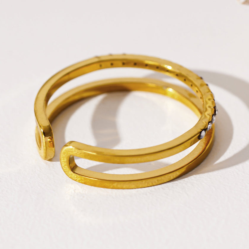 AIZA : Bague à deux anneaux avec pavage de zircons et surfaces contrastées à finition lisse.