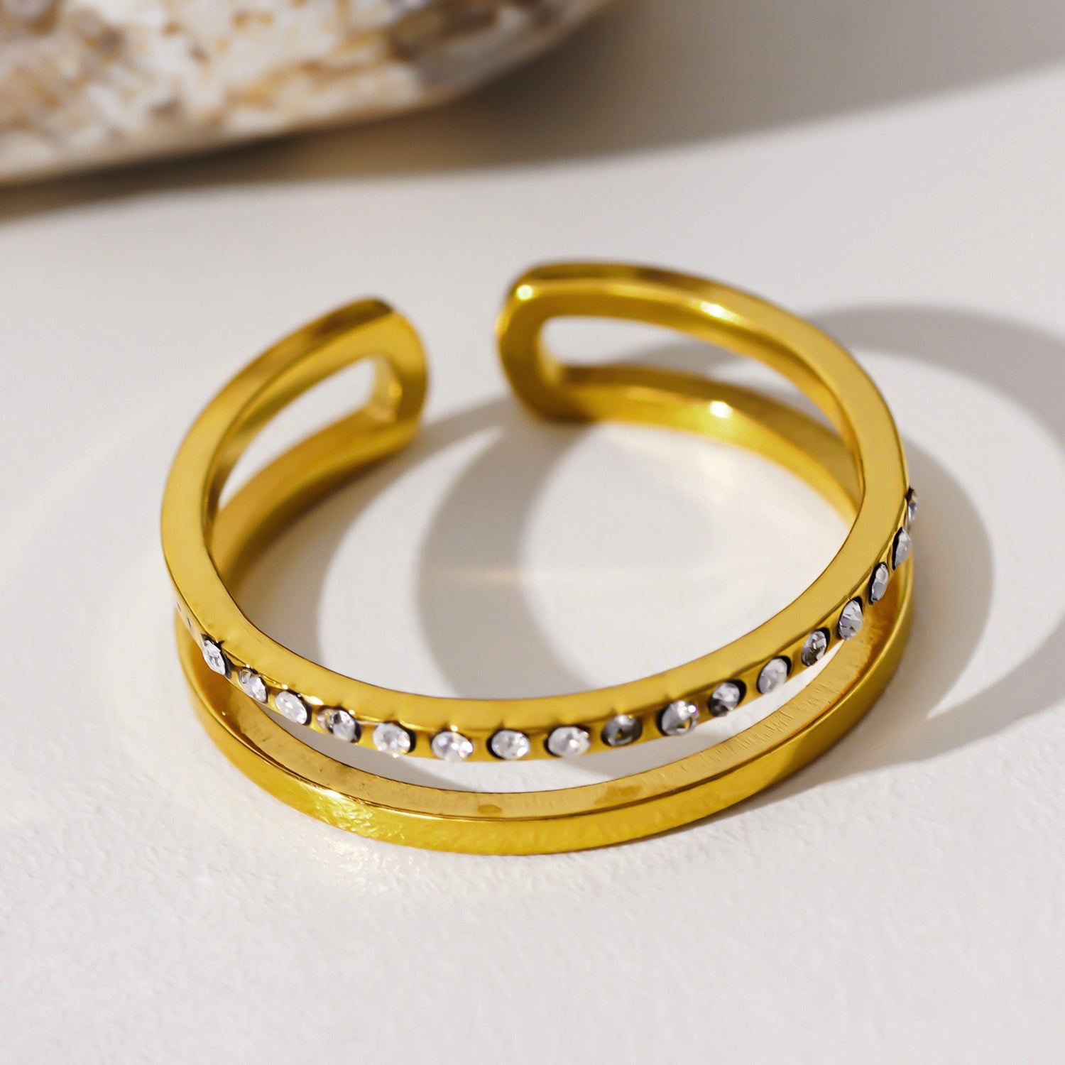 AIZA : Bague à deux anneaux avec pavage de zircons et surfaces contrastées à finition lisse.