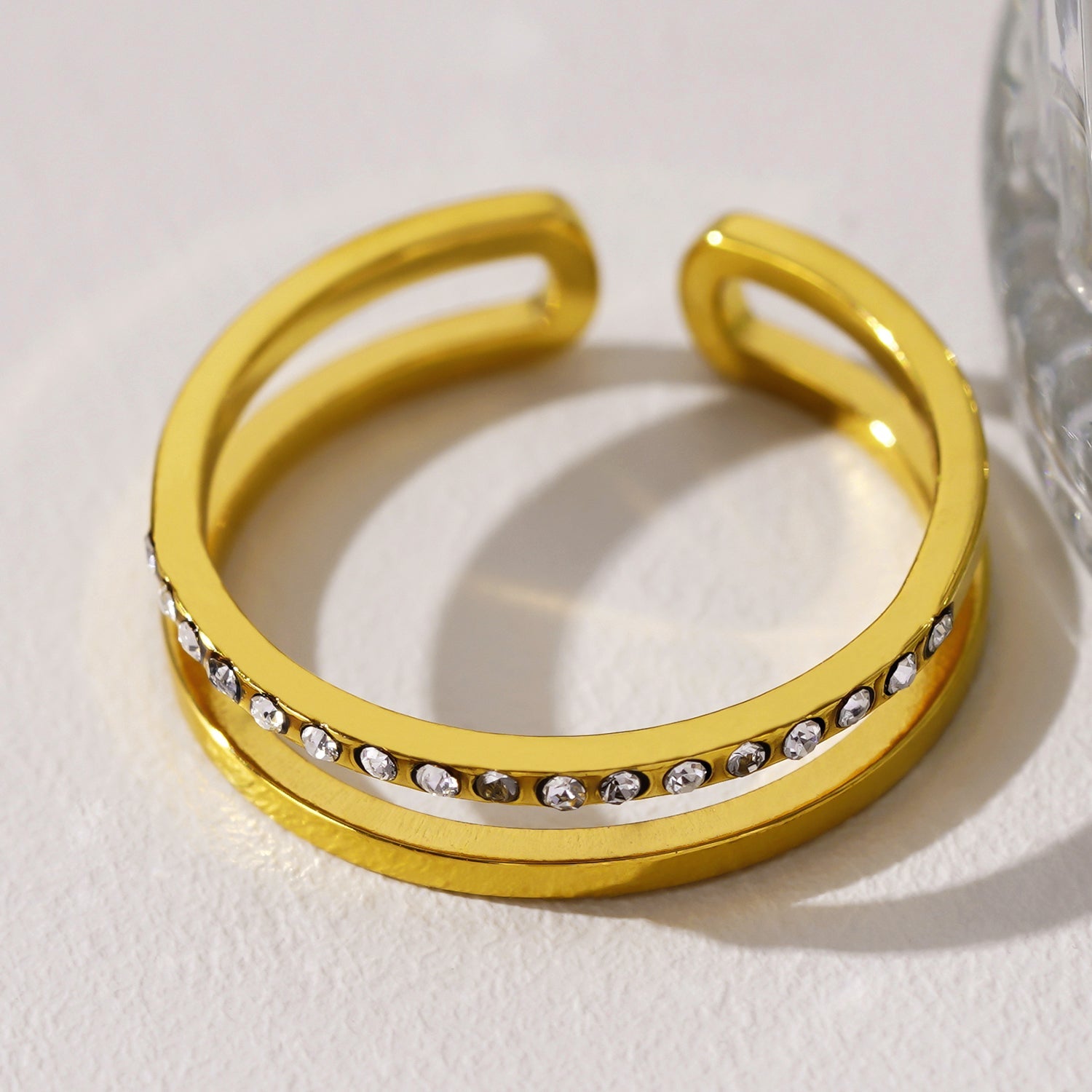 AIZA : Bague à deux anneaux avec pavage de zircons et surfaces contrastées à finition lisse.