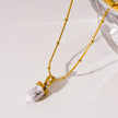 AMELIE : Collier avec pendentif en pierre turquoise blanche, accroché à une chaîne perlée texturée imitant la peau de serpent.