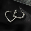 Style ANJAR Or Blanc (Ton Argent) : Boucles d'oreilles en forme de cœur serties de pierres précieuses en zircone.