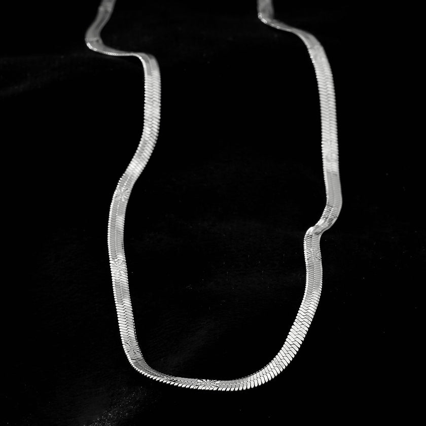 BAMBURG : Collier en chaîne argentée avec motif peau de serpent et étoiles en relief.