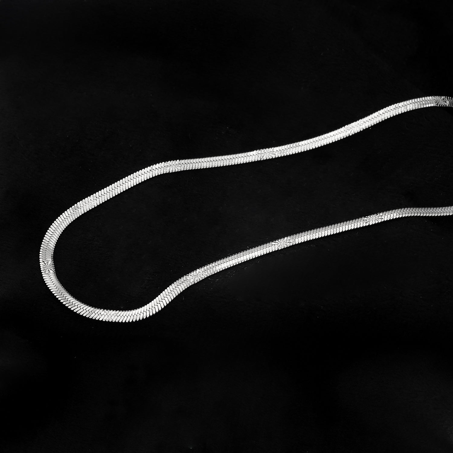 BAMBURG : Collier en chaîne argentée avec motif peau de serpent et étoiles en relief.