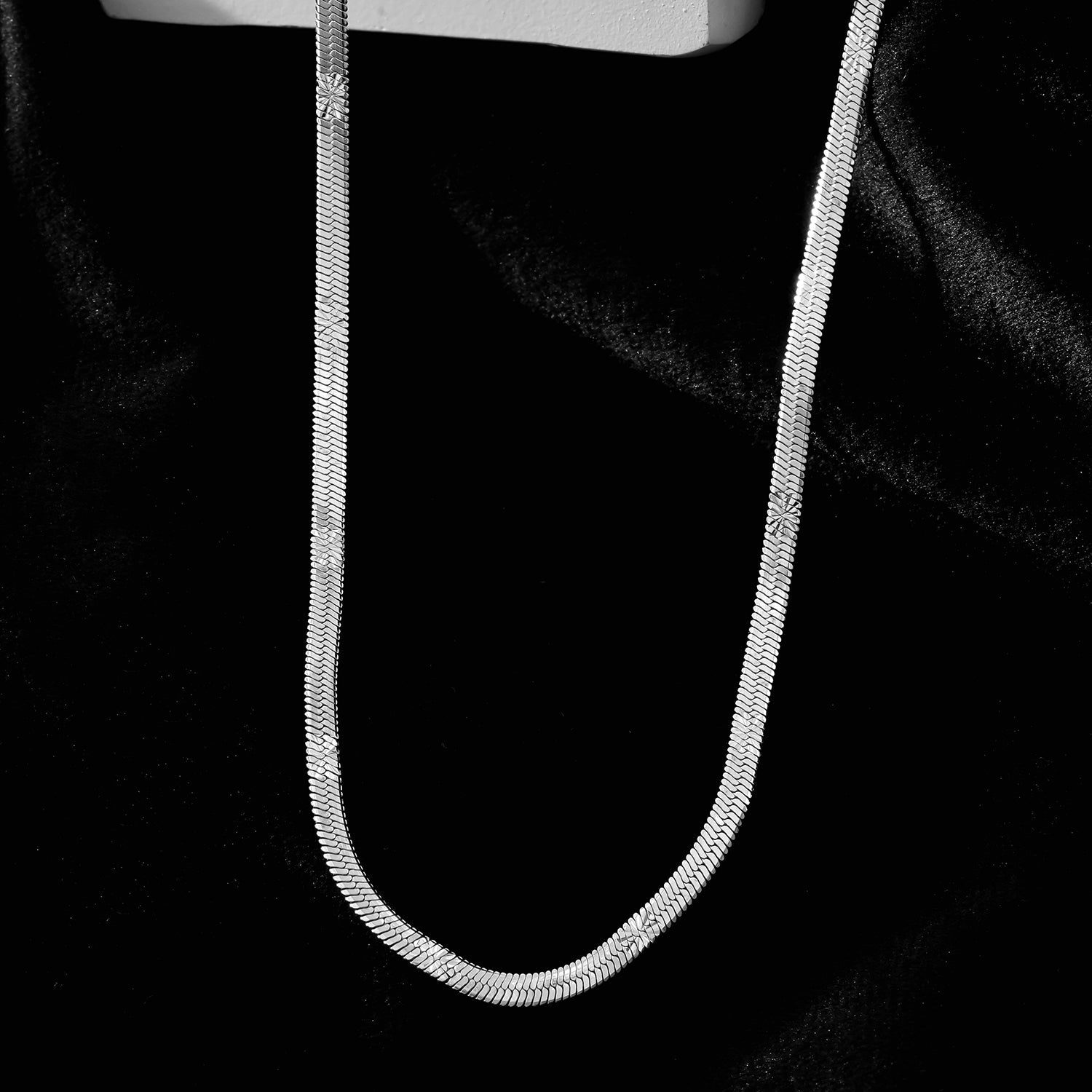 BAMBURG : Collier en chaîne argentée avec motif peau de serpent et étoiles en relief.