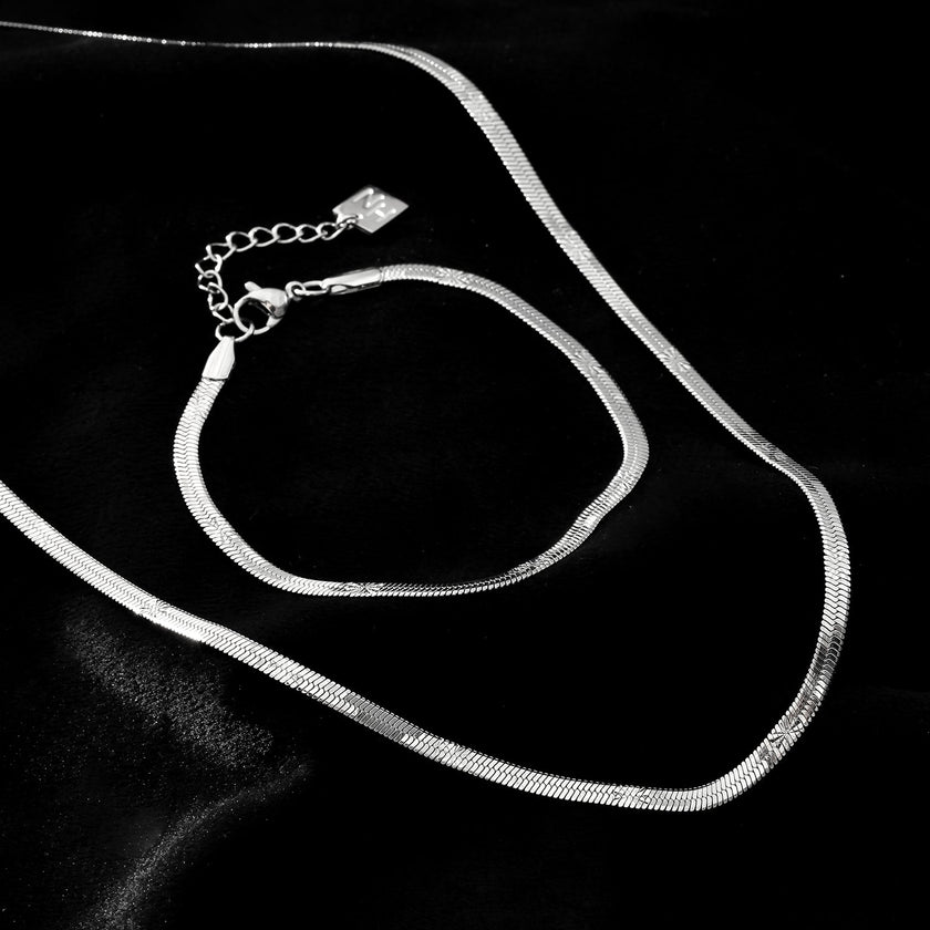 BAMBURG : Collier en chaîne argentée avec motif peau de serpent et étoiles en relief.