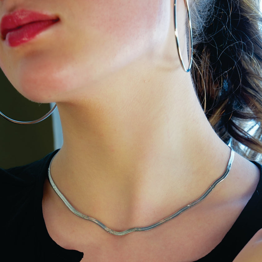 BAMBURG : Collier en chaîne argentée avec motif peau de serpent et étoiles en relief.
