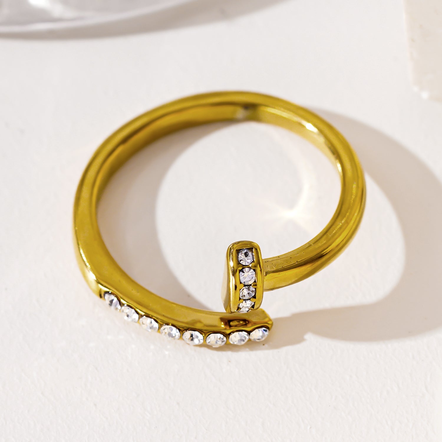 CHARISSE : Bague à ongles torsadée au style industriel et chic, ornée de pavés de zircons.