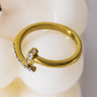 CHARISSE : Bague à ongles torsadée au style industriel et chic, ornée de pavés de zircons.