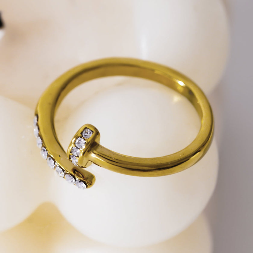 CHARISSE : Bague à ongles torsadée au style industriel et chic, ornée de pavés de zircons.