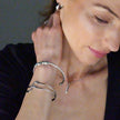 CHITRA : Bracelet au style industriel et chic avec des bandes parallèles de formes abstraites en or blanc argenté.