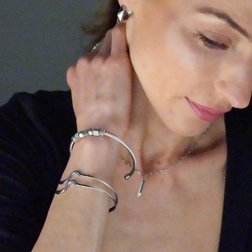 CHITRA : Bracelet au style industriel et chic avec des bandes parallèles de formes abstraites en or blanc argenté.