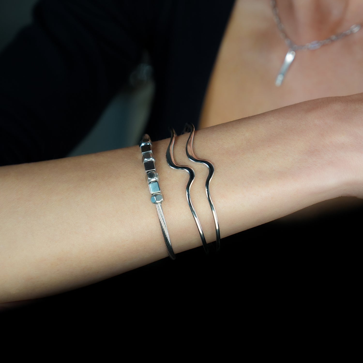CHITRA : Bracelet au style industriel et chic avec des bandes parallèles de formes abstraites en or blanc argenté.