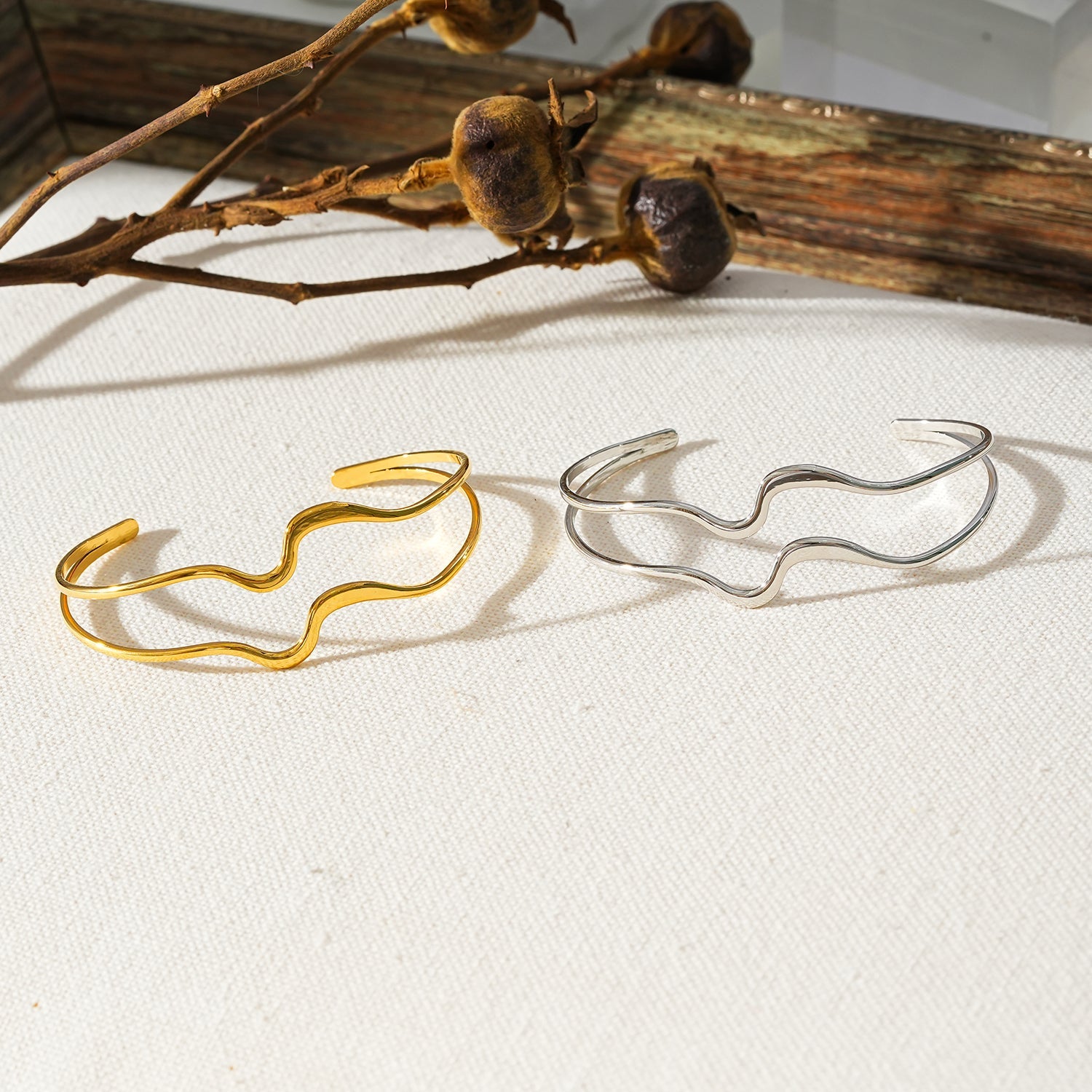 CHITRA : Bracelet au style industriel et chic avec des bandes parallèles de formes abstraites en or blanc argenté.