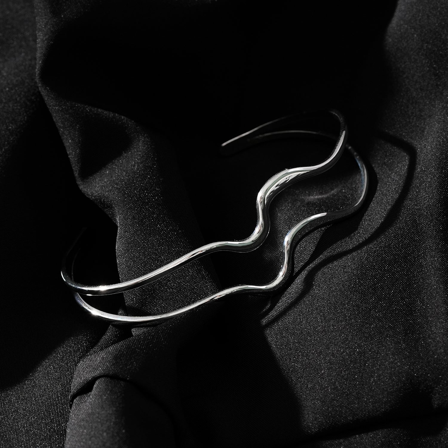 CHITRA : Bracelet au style industriel et chic avec des bandes parallèles de formes abstraites en or blanc argenté.