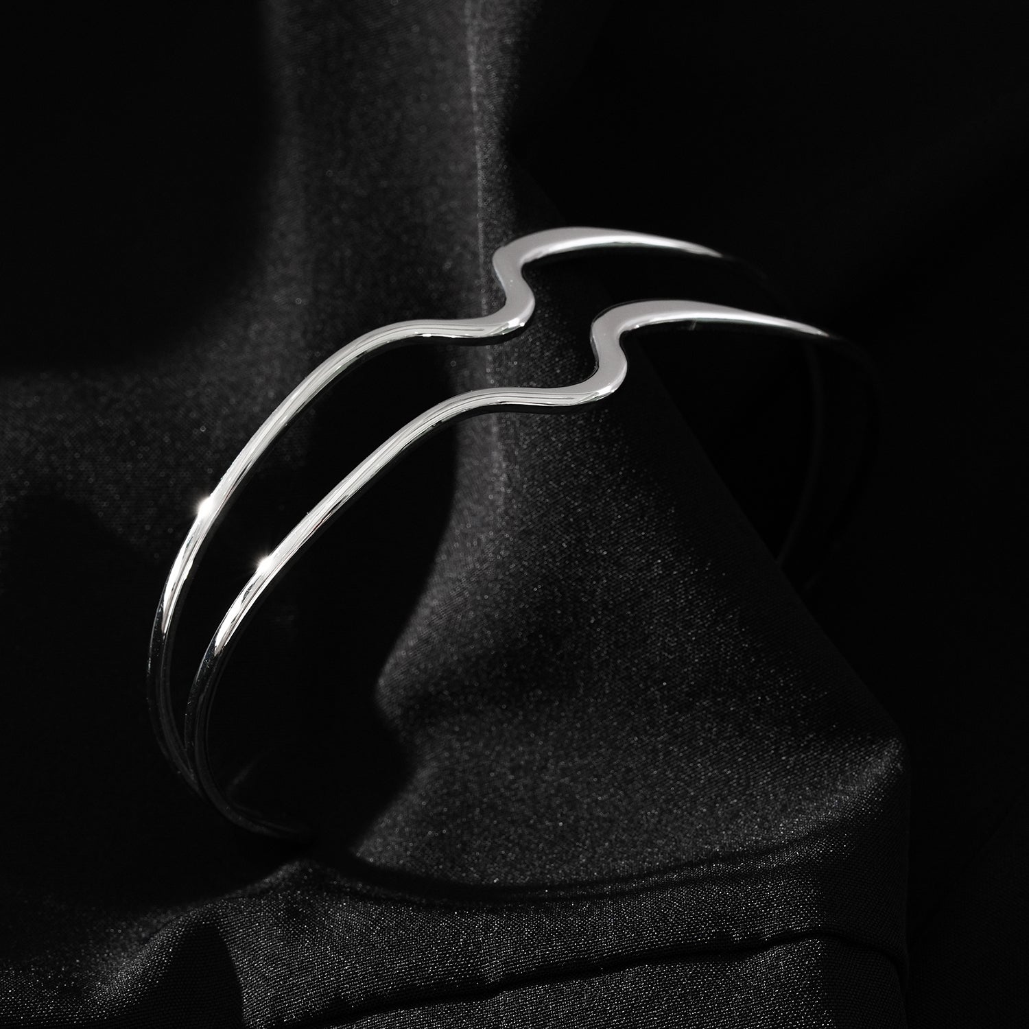 CHITRA : Bracelet au style industriel et chic avec des bandes parallèles de formes abstraites en or blanc argenté.