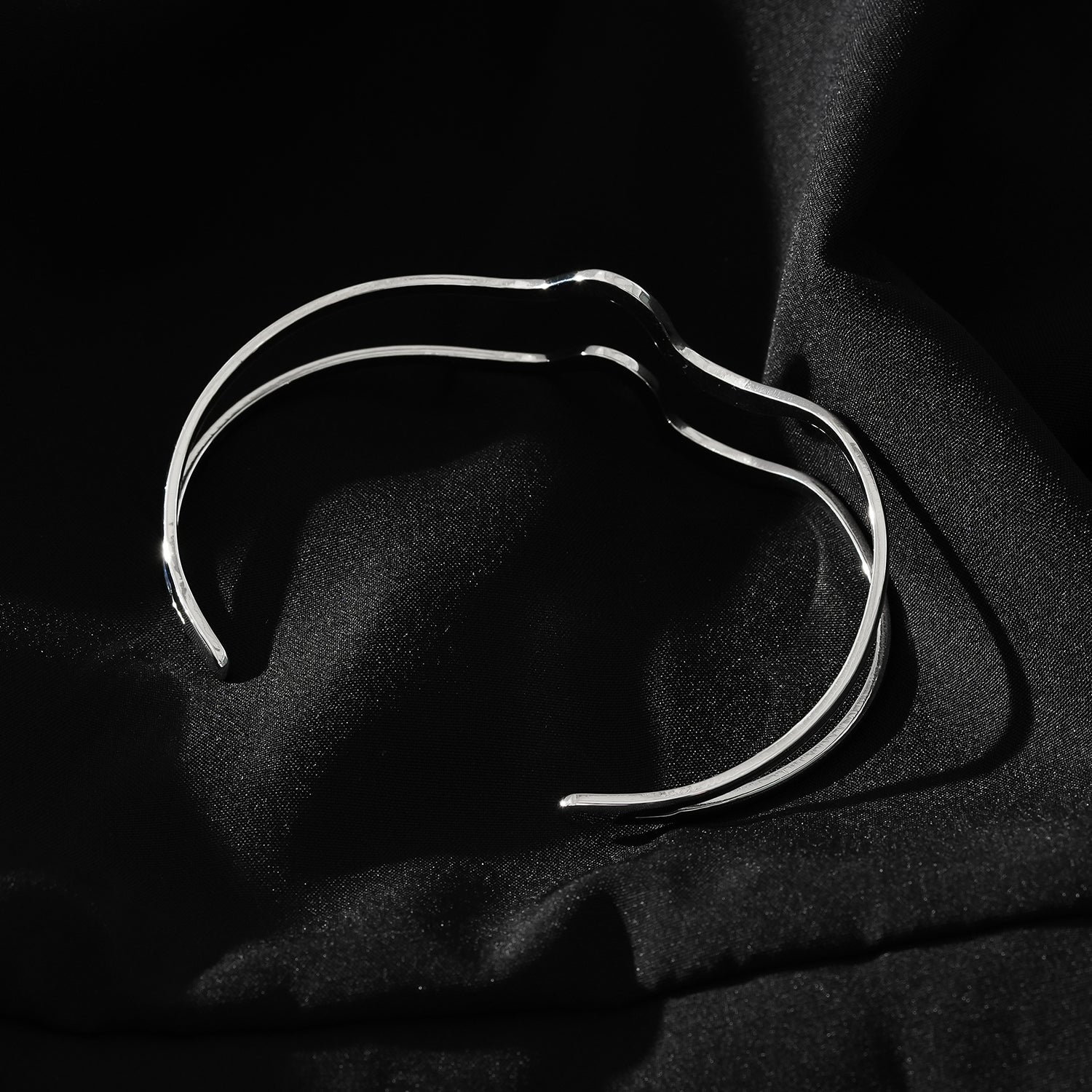 CHITRA : Bracelet au style industriel et chic avec des bandes parallèles de formes abstraites en or blanc argenté.
