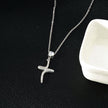 CRISTO Argent (Or Blanc) : Collier à fine chaîne avec pendentif croix abstraite texturée sertie de zircone.