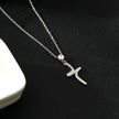 CRISTO Argent (Or Blanc) : Collier à fine chaîne avec pendentif croix abstraite texturée sertie de zircone.