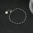 DEMELZA Or Blanc (Couleur Argentée) : Bracelet essentiel pour tous les jours avec de délicates perles carrées.