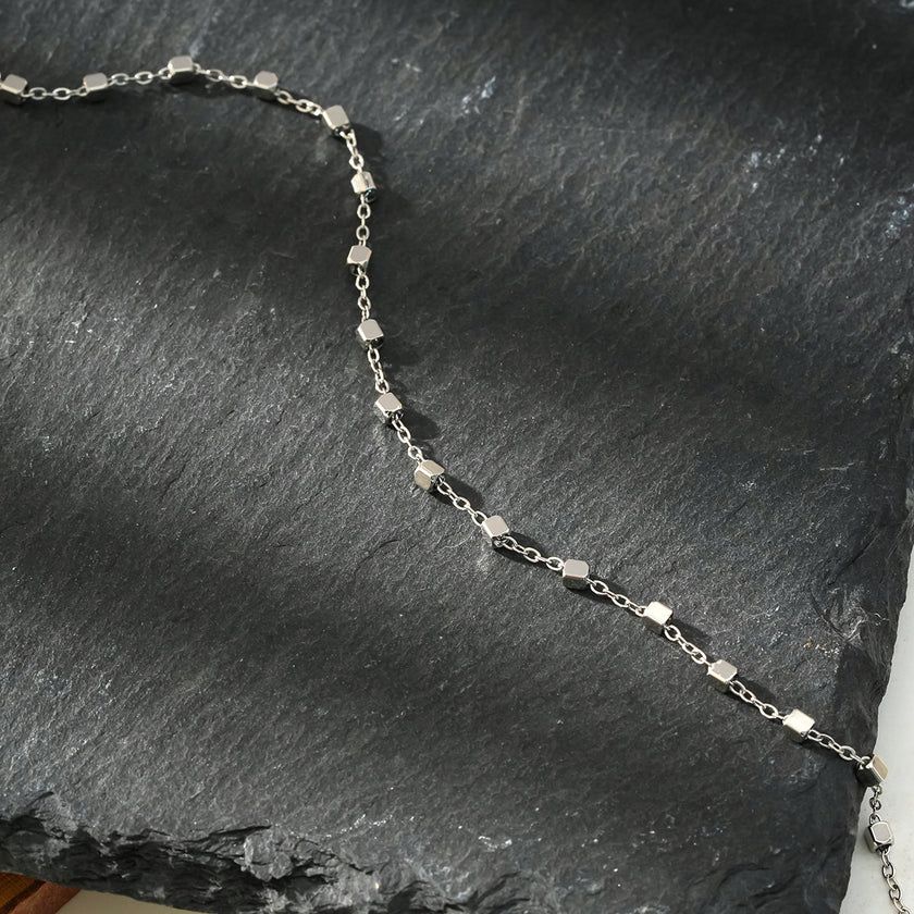 DEMELZA Or Blanc (Couleur Argentée) : Bracelet essentiel pour tous les jours avec de délicates perles carrées.