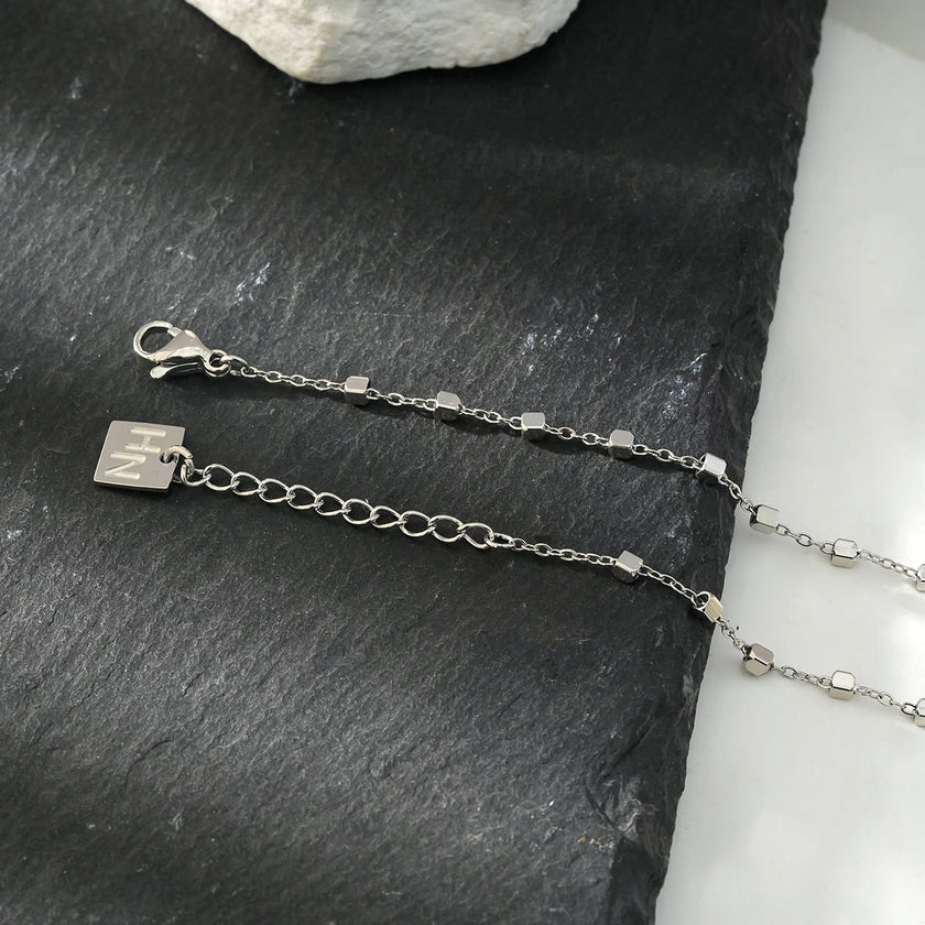 DEMELZA Or Blanc (Couleur Argentée) : Bracelet essentiel pour tous les jours avec de délicates perles carrées.