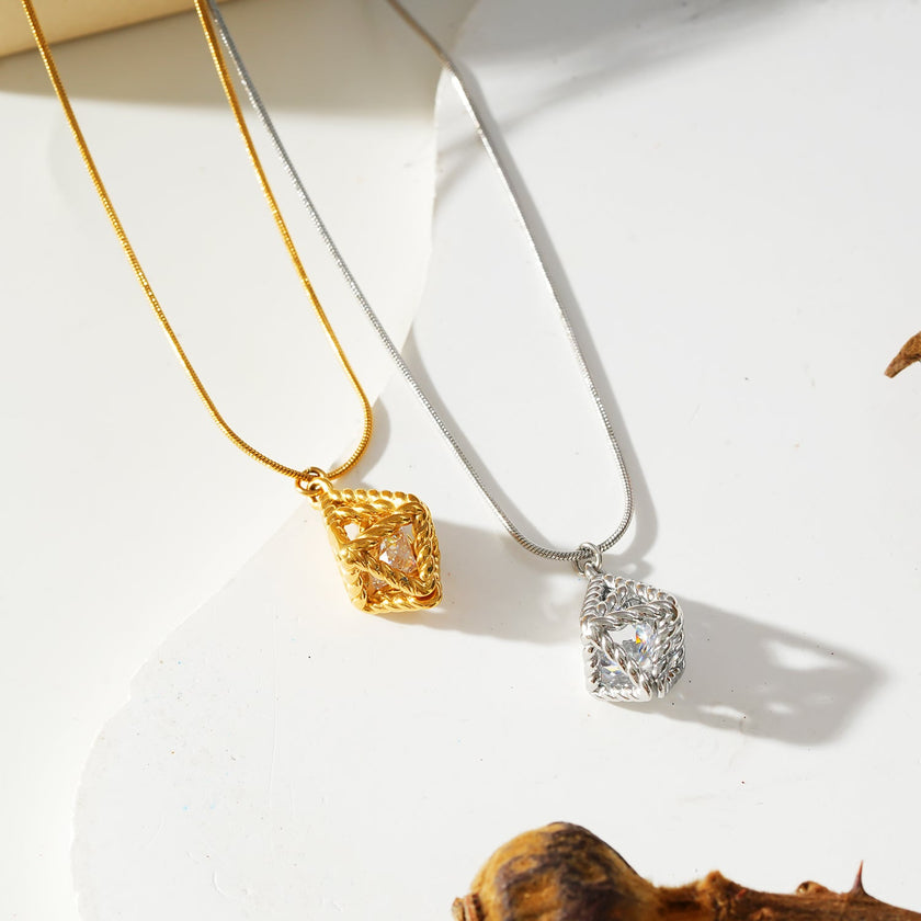 Style KARJAT : Collier à chaîne dorée avec pendentif en zircone géométrique en cage.