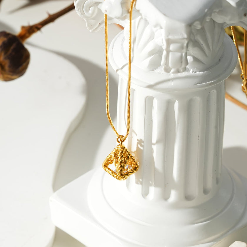 Style KARJAT : Collier à chaîne dorée avec pendentif en zircone géométrique en cage.