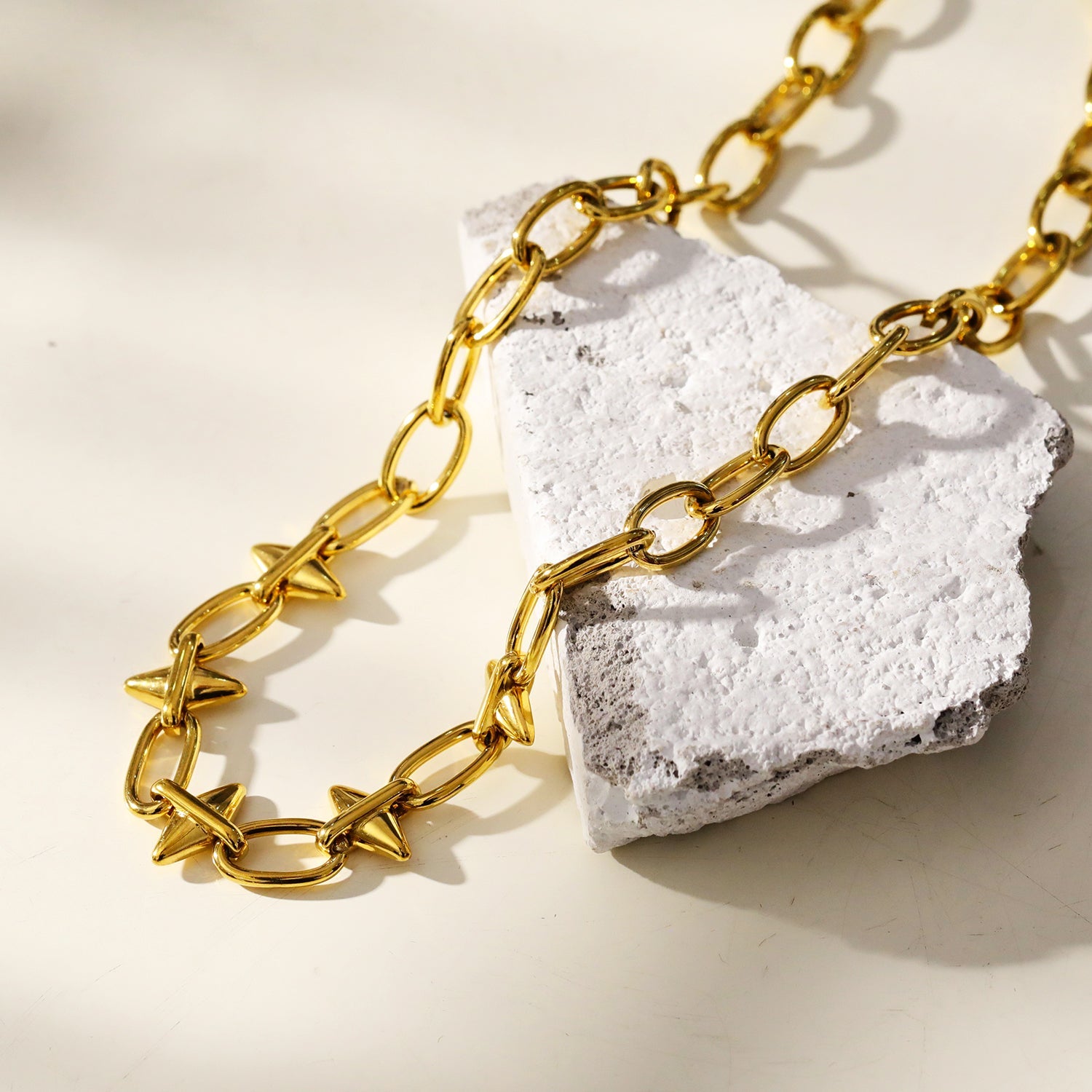 ELLINOR : Collier à breloques en forme de goutte de diamant, style industriel chic.