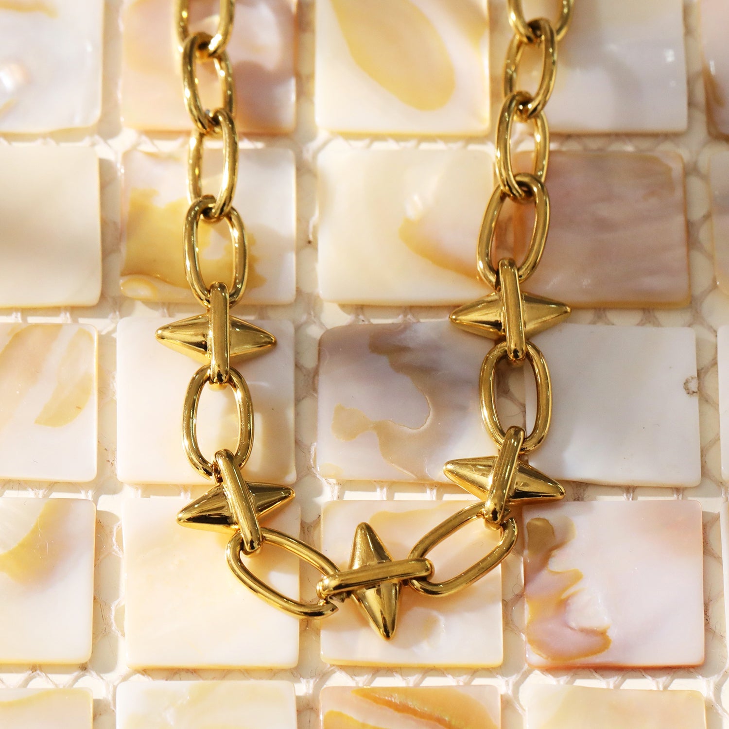ELLINOR : Collier à breloques en forme de goutte de diamant, style industriel chic.