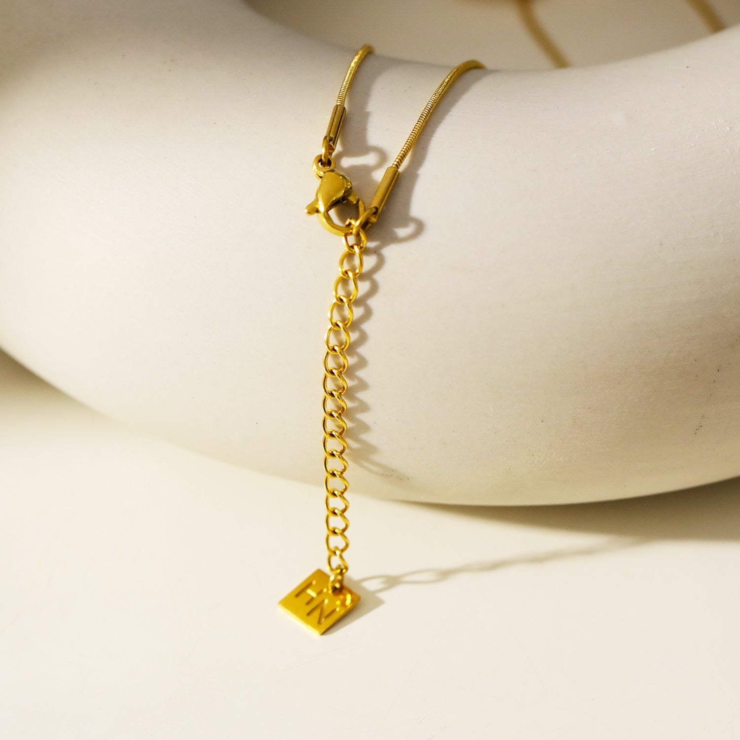 GARNA Gold : Mini chaîne à maillons serpentin ornés de breloques ovales serties de zircons.