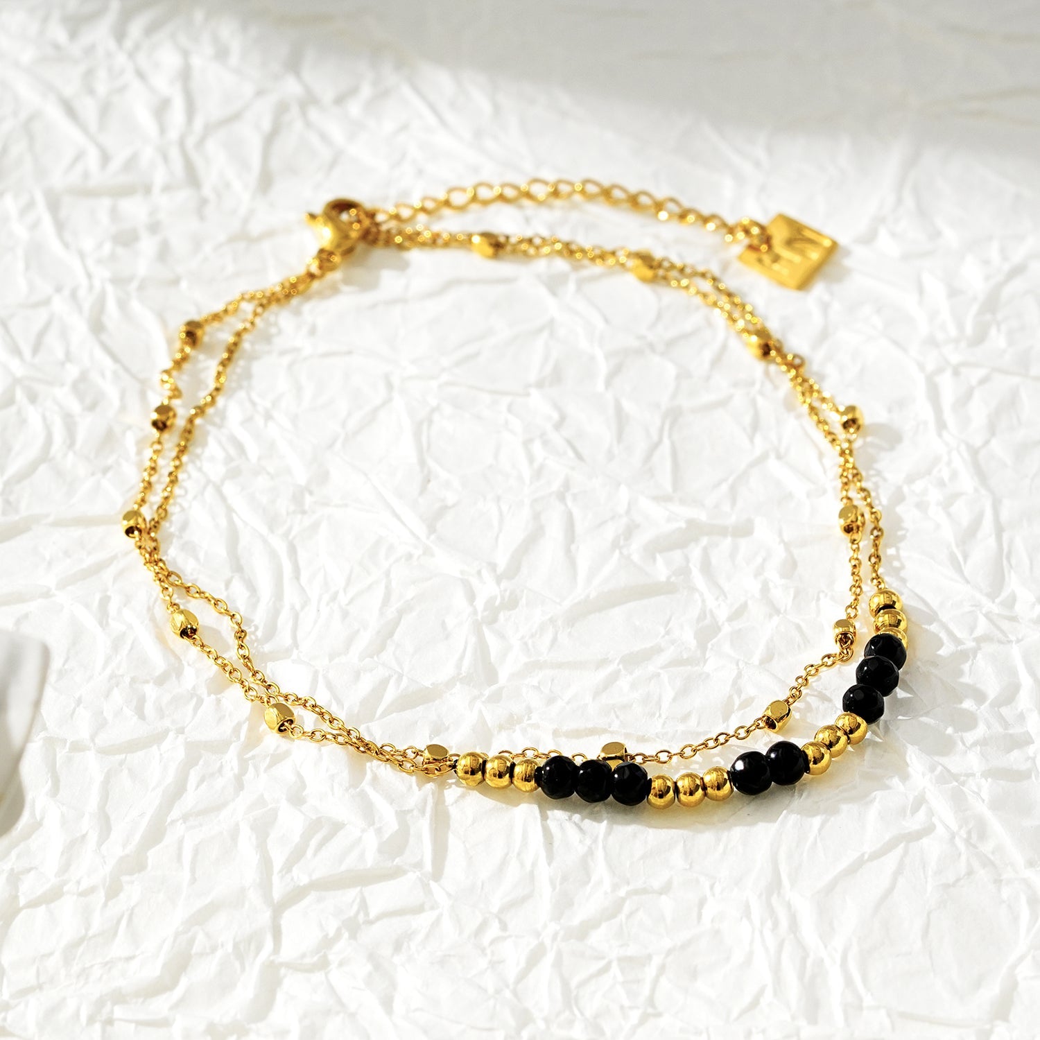 HILDA LG : Bracelet de cheville 2-en-1 avec perles carrées et perles rondes, noir et or.