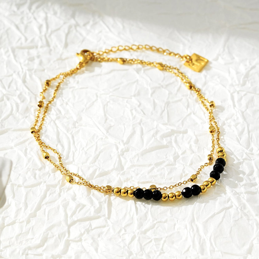 HILDA LG : Bracelet de cheville 2-en-1 avec perles carrées et perles rondes, noir et or.