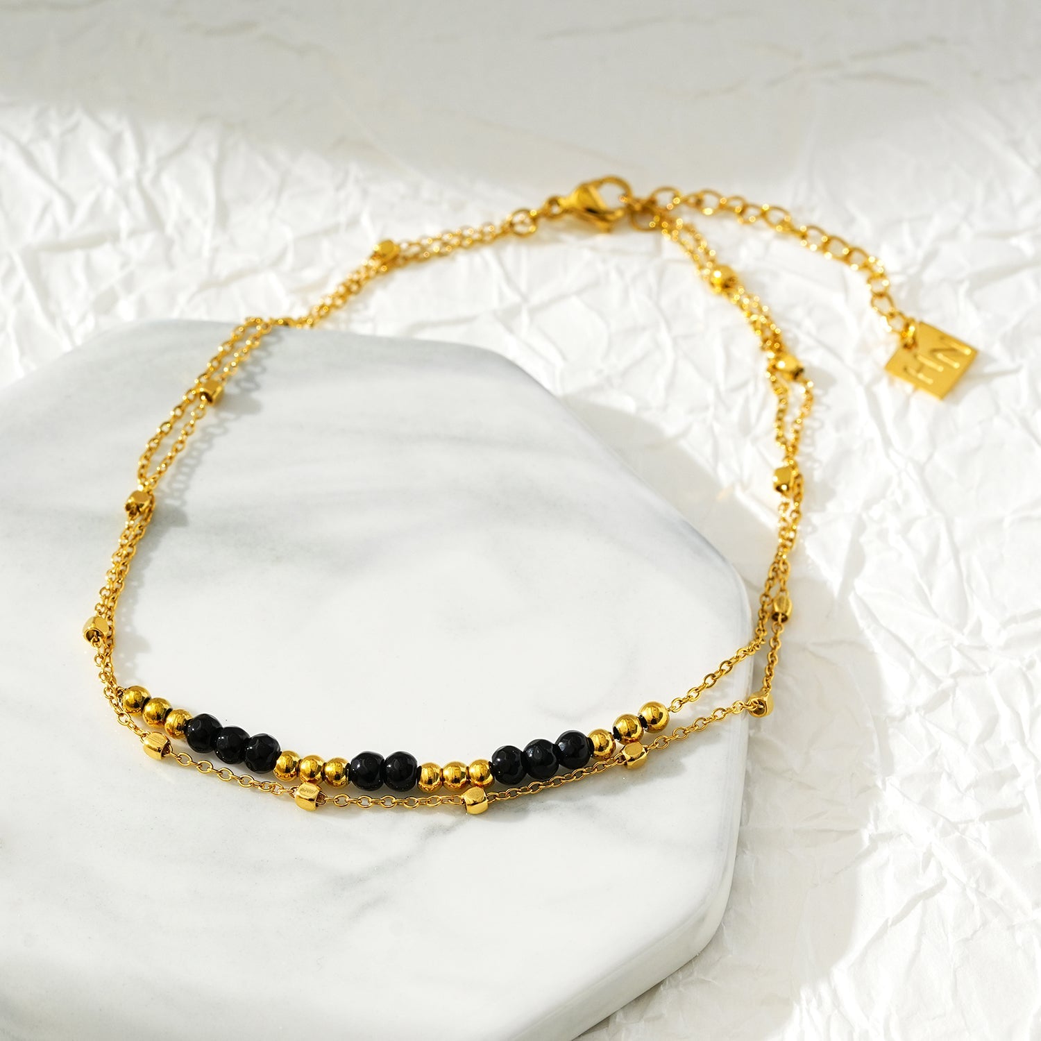 HILDA LG : Bracelet de cheville 2-en-1 avec perles carrées et perles rondes, noir et or.