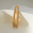 Style HILO : Boucles d'oreilles créoles en forme de zircone pavée incurvée en argent.