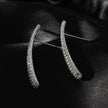 Style HILO : Boucles d'oreilles créoles en forme de zircone pavée incurvée en argent.