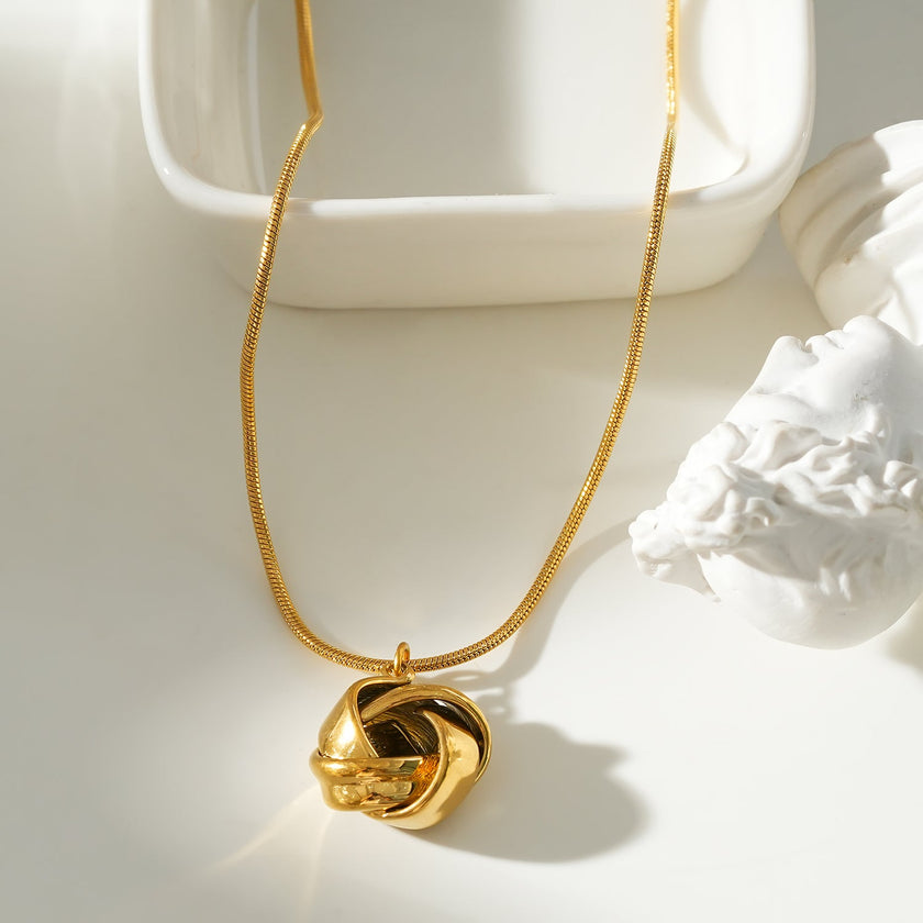 JASPUR : Collier serpentin avec pendentif nœud d'amour en or.
