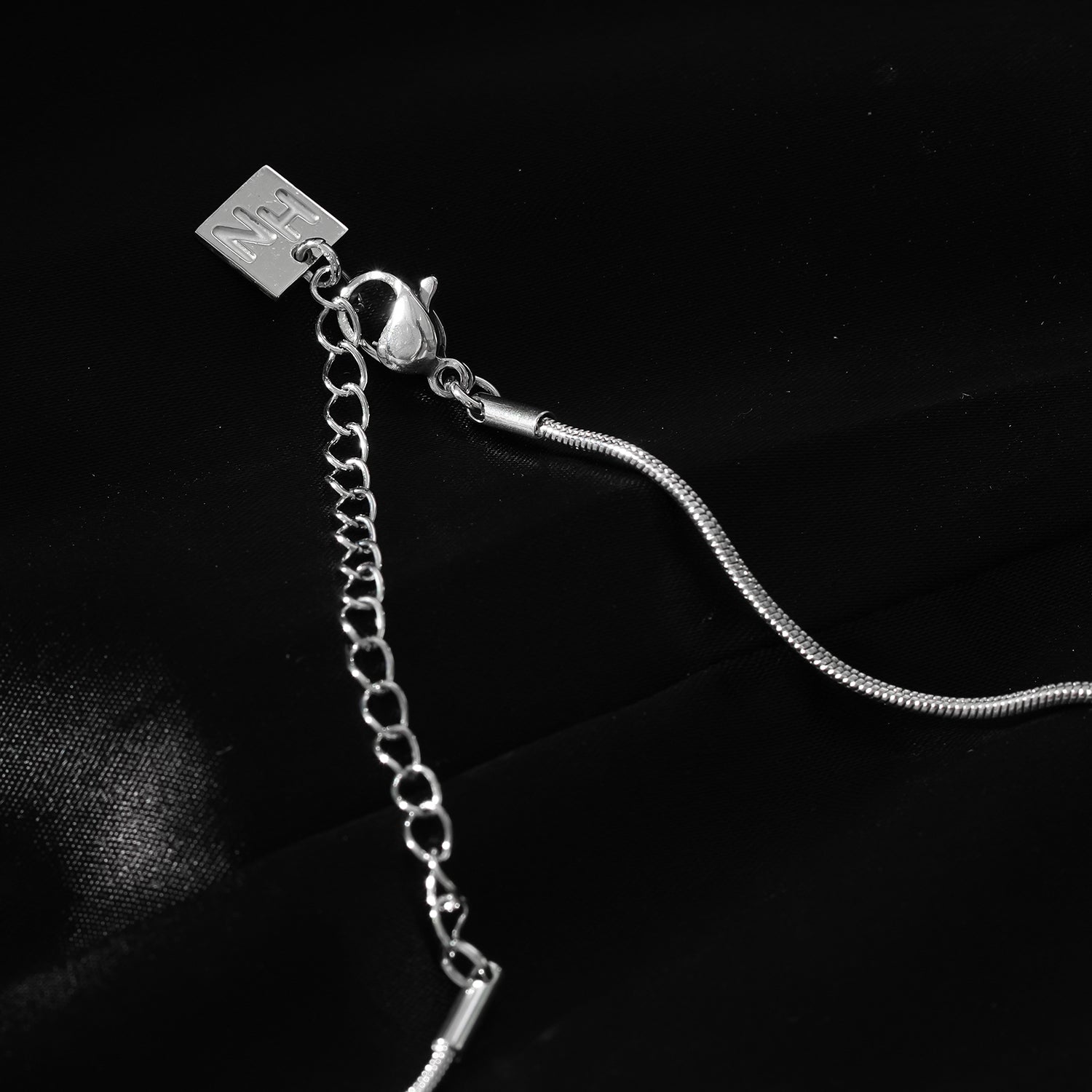 Style JASPUR : Collier chaîne imitation peau de serpent avec pendentif nœud d'amour en or blanc (argenté)