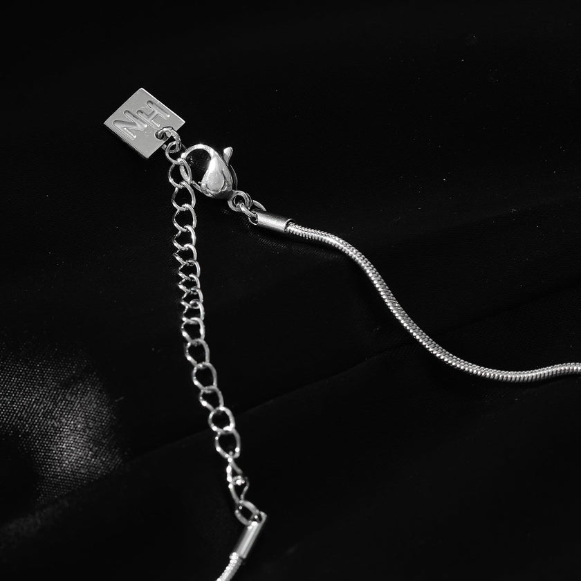 Style JASPUR : Collier chaîne imitation peau de serpent avec pendentif nœud d'amour en or blanc (argenté)