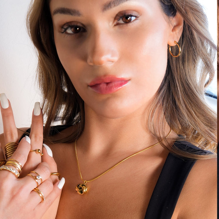 JASPUR : Collier serpentin avec pendentif nœud d'amour en or.