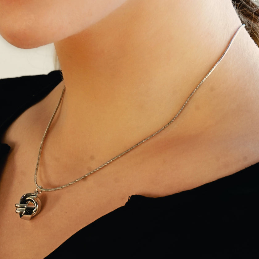Style JASPUR : Collier chaîne imitation peau de serpent avec pendentif nœud d'amour en or blanc (argenté)