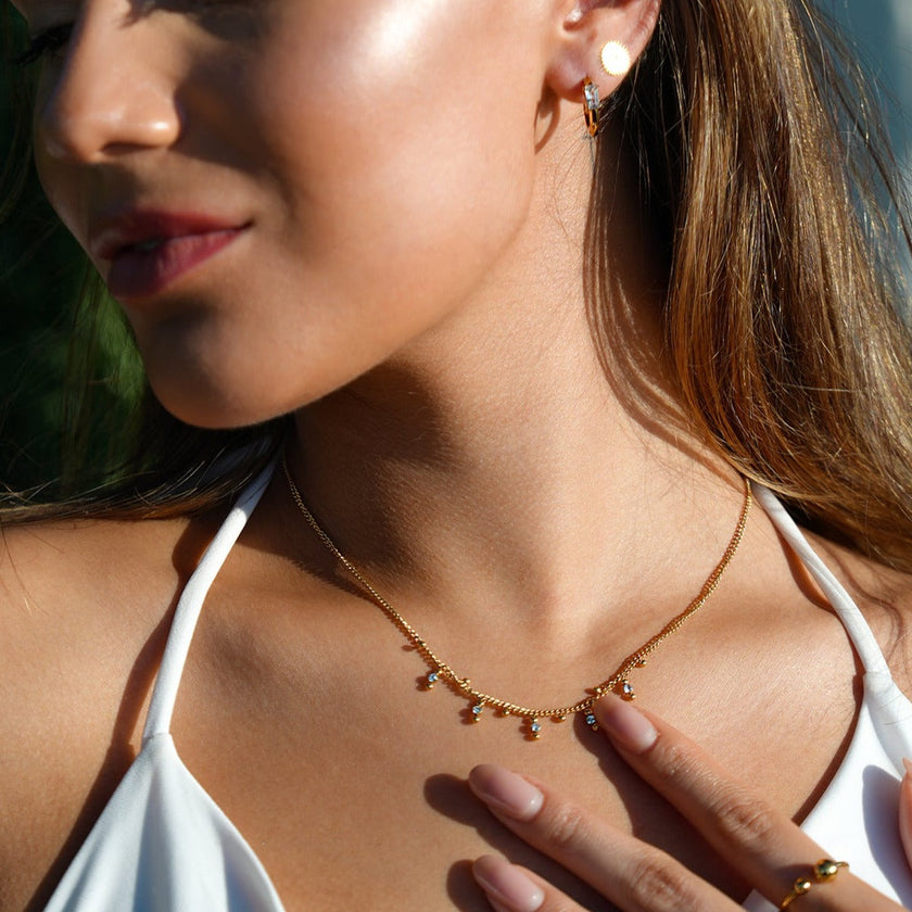 Style KALPI : Collier en chaîne à perles et zircons dorés.