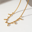 Style KALPI : Collier en chaîne à perles et zircons dorés.