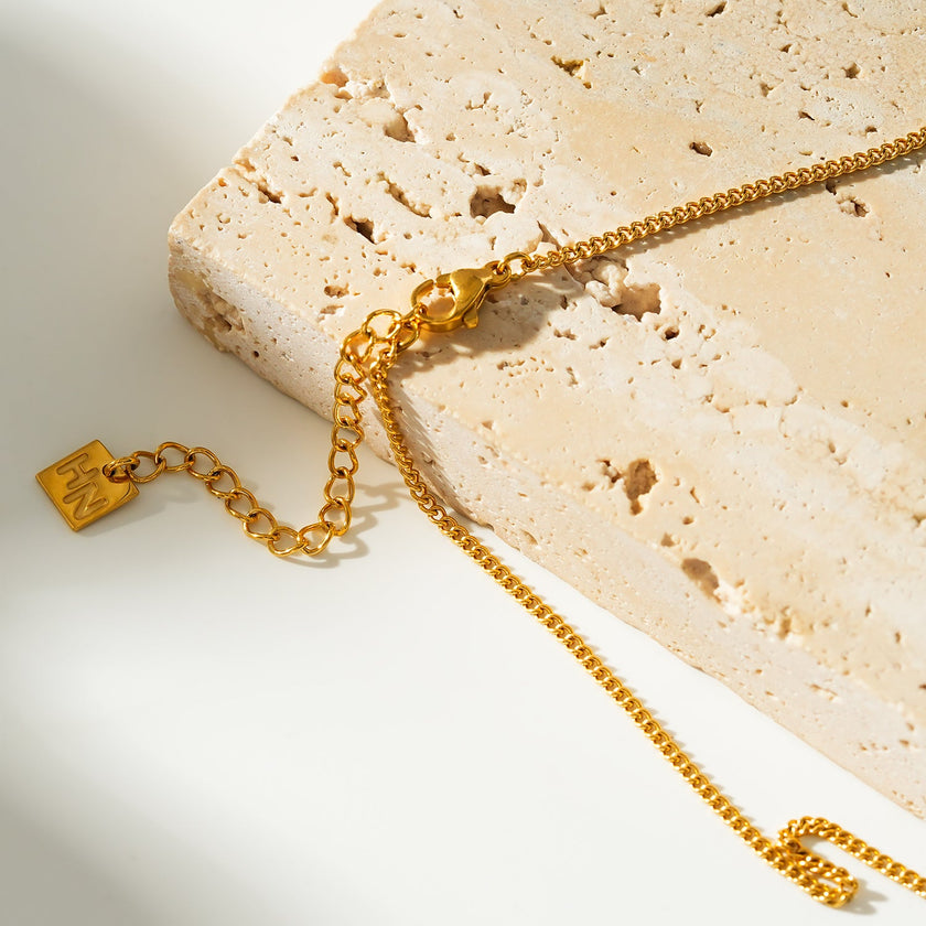 Style KALPI : Collier en chaîne à perles et zircons dorés.