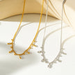 Style KALPI : Collier en chaîne à perles et zircons dorés.