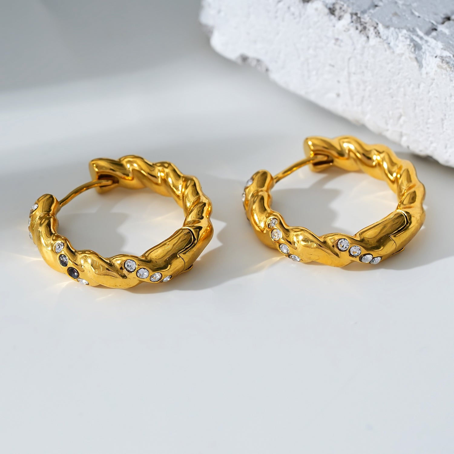 Style KAMENZ: Twisted Textured Hoop Earrings with Zirconia Embellishments.