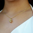 Style KARJAT : Collier à chaîne dorée avec pendentif en zircone géométrique en cage.
